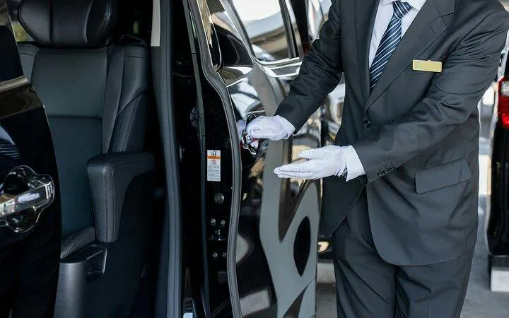 Private chauffeur opening car door for Osaka City to Kansai Airport transfer.