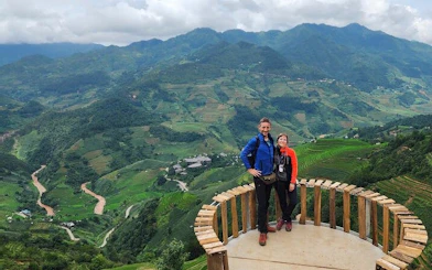 Couple on a wooden platform overlooking terraced rice fields in Mu Cang Chai, Vietnam.