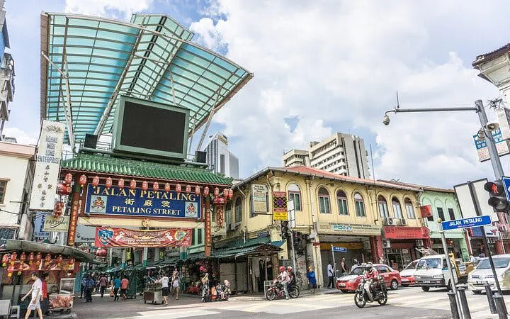 Petaling Street entrance in Kuala Lumpur, bustling with people and shops.