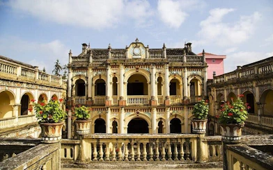 Historic building at Bac Ha Market, Sapa, with ornate arches and potted plants.