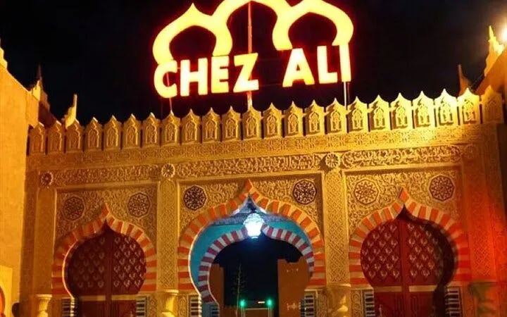 Chez Ali entrance illuminated at night, Marrakesh folklore show location.