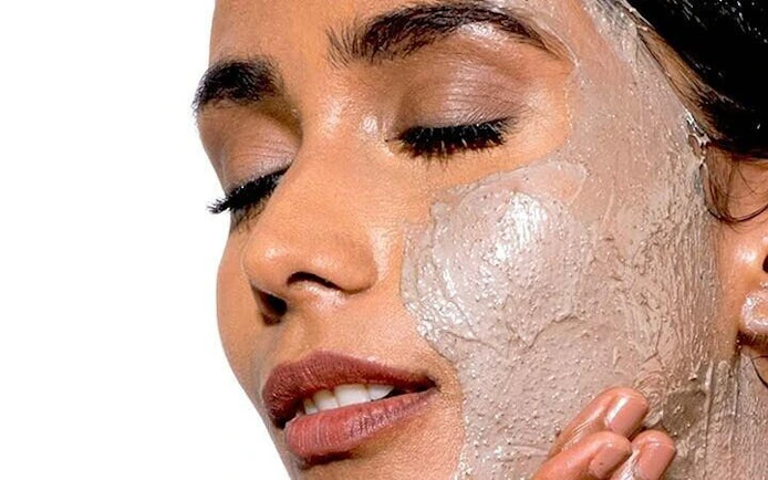 Woman enjoying facial treatment during Moroccan Hammam ritual in Marrakesh bathhouse.