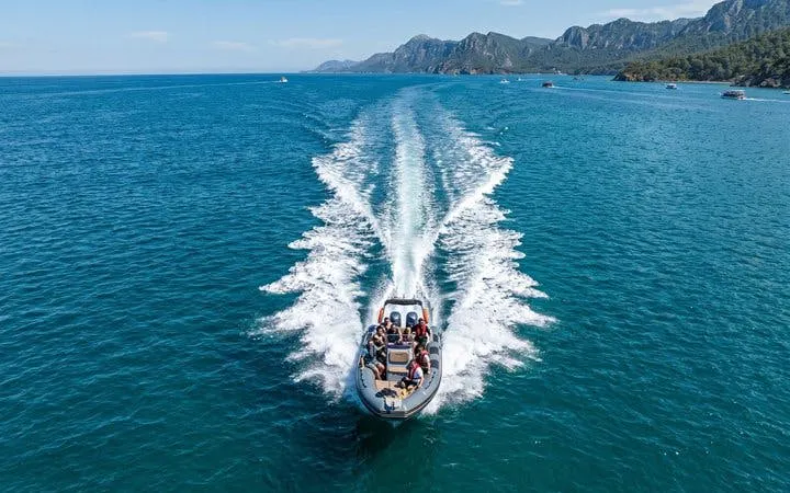 Boat cruising on the Mediterranean Sea near Antalya with passengers enjoying the view.