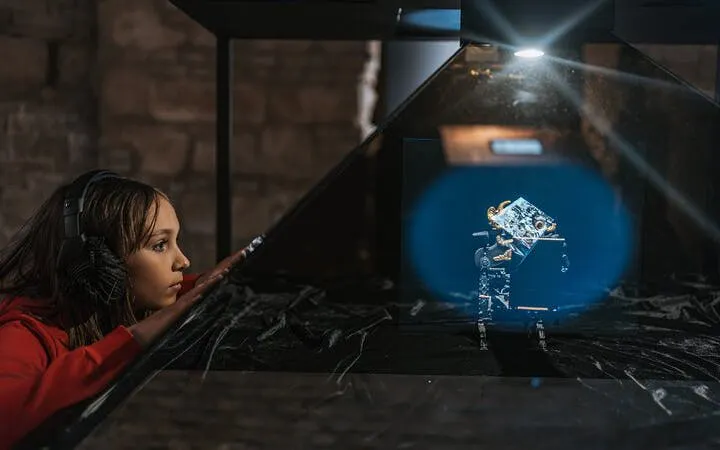 Person observing holographic display at Time Machine Budapest exhibition.