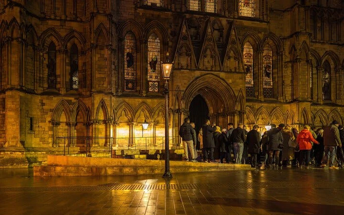 Group gathered outside York Minster for haunted walking tour at night.