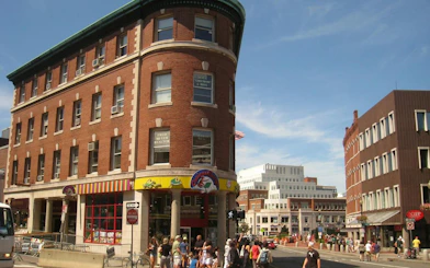 Harvard Square street view with historic buildings and pedestrians in Boston.