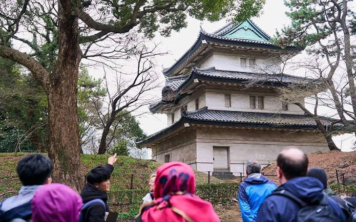 Visitors on a guided tour near a historic building at Tokyo Imperial Palace.
