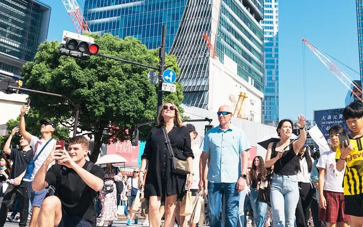 Shibuya Crossing with tourists exploring Tokyo's bustling streets and modern architecture.