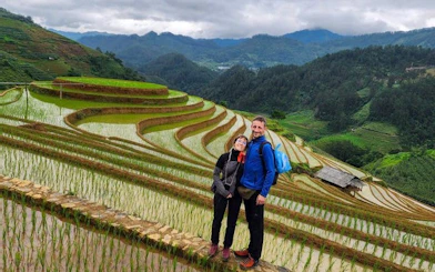 Couple standing on Mu Cang Chai rice terraces during private tour with Hmong guide.