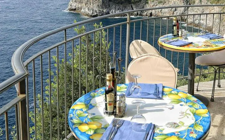 Seaside dining with lemon-themed tables overlooking the Amalfi Coast.