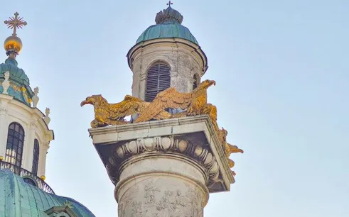 Karlskirche column with golden eagles, part of the Espionage in Vienna self-guided city exploration game.