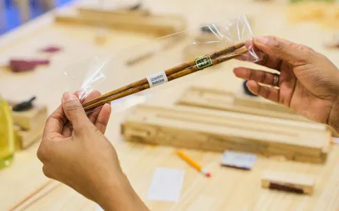 Chopsticks in packaging at Kyoto Arashiyama workshop table with tools.