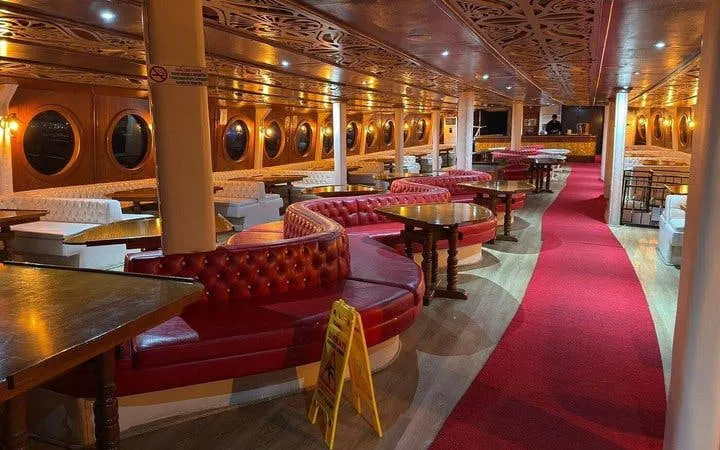 Interior of GONSTER Deluxe Pirate Boat with red seating and tables, Kemer tour.