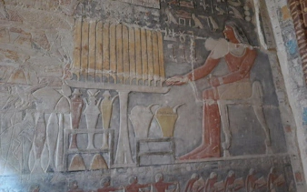 Ancient Egyptian wall relief depicting a seated figure with offerings, Model Village Egypt tour.