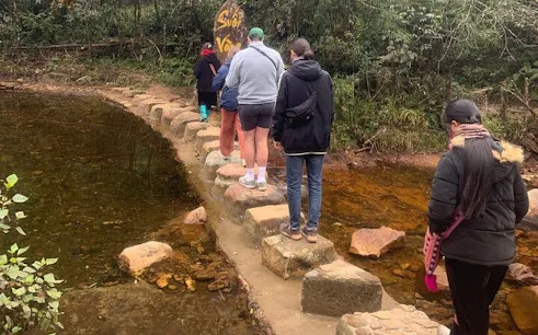 Tourists crossing stepping stones on a stream in Sa Pa during a motorbike tour.