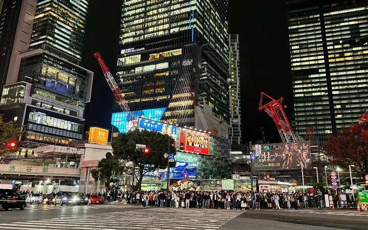 Shibuya Crossing at night with crowds and illuminated skyscrapers, Tokyo walking tour.