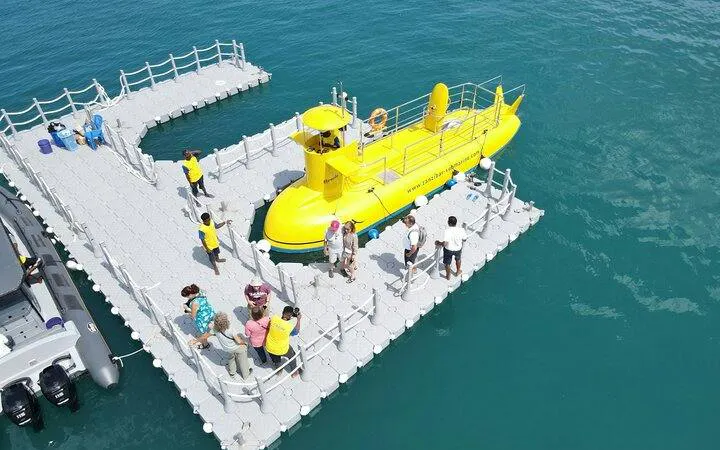 Semi-submarine docked with tourists boarding for Zanzibar sunset cruise.