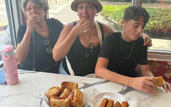 Visitors enjoying Cuban pastries and croquettes during Little Havana walking tour, Miami.