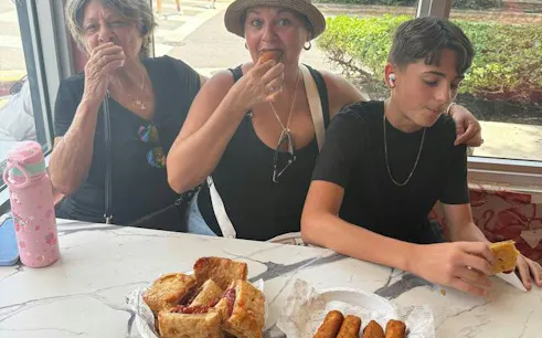 Visitors enjoying Cuban pastries and croquettes during Little Havana walking tour, Miami.