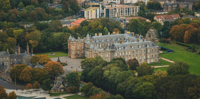 Aerial view of Holyrood Palace surrounded by gardens in Edinburgh Old Town.