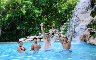 Tourists enjoying a swim in a jungle waterfall pool in Punta Cana.