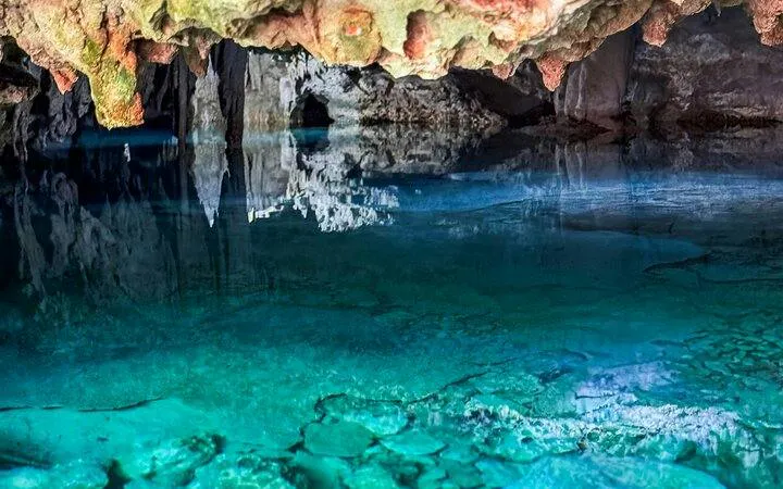 Yaxmuul cenote with clear turquoise water and rock formations, Tulum.