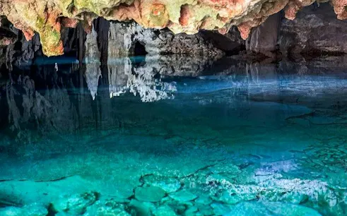 Yaxmuul cenote with clear turquoise water and rock formations, Tulum.