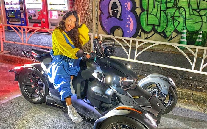 Can-am Ryker parked in Asakusa with rider, vending machines and graffiti in background.