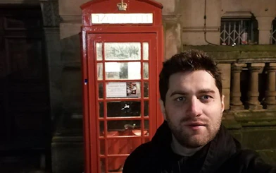 Red phone booth in Birmingham at night during haunted city exploration game.
