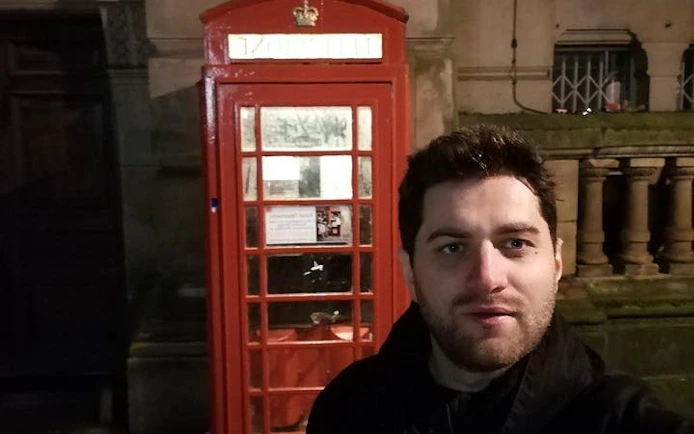 Red phone booth in Birmingham at night during haunted city exploration game.