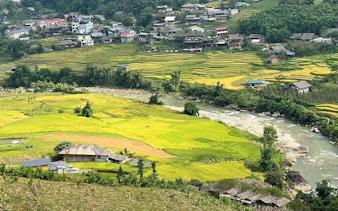 Sapa rice terraces and river with village homes in the background, Vietnam.