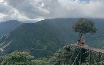 Sapa mountain view with tourists on a wooden platform, part of motorbike tour to waterfall and Pusamcap Cave.