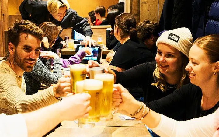 Group enjoying drinks at a bar during Shinjuku night tour in Tokyo.