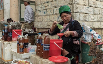 Local vendor preparing traditional drinks at a Sapa market during a guided food tour.