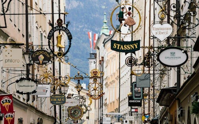 Salzburg street with historic signs and Austrian flag, part of music history exploration game.