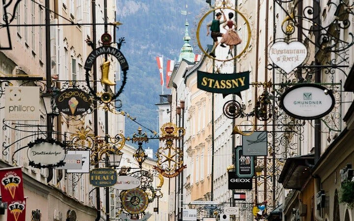Salzburg street with historic signs and Austrian flag, part of music history exploration game.