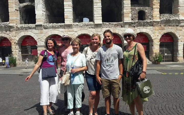 Group of tourists in front of Arena di Verona during guided city tour.