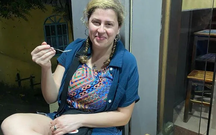 Woman enjoying street food during Hanoi Old Quarter cyclo tour.