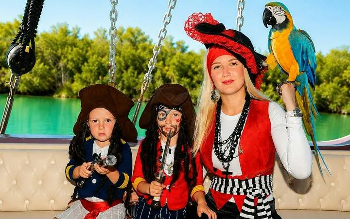 Pirate-themed boat trip in Alanya with children in costumes and a parrot on deck.