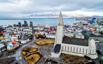 Hallgrímskirkja church in Reykjavik, Iceland, with cityscape and ocean view.