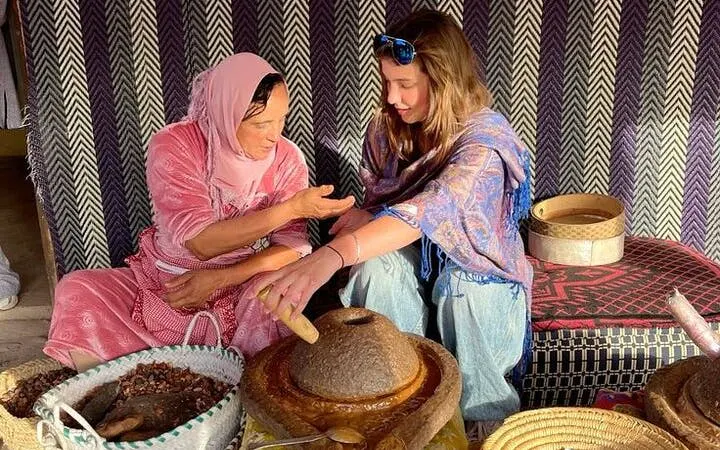 Moroccan woman teaching traditional cooking technique in Marrakesh class.