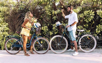Couple with bicycles enjoying a tropical path in Zanzibar, Tanzania.