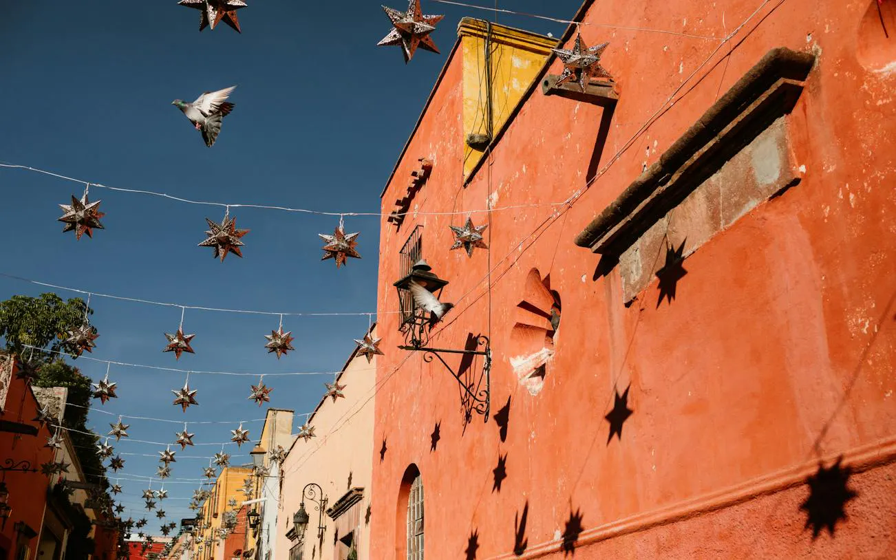 Star-shaped lanterns hanging above a colorful street in San Miguel de Allende Historic Center, Mexico.