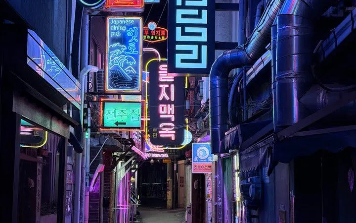 Neon-lit alley in Seoul with signs for dining pubs, part of Chimaek night food tour.