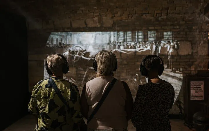 Visitors with headphones view historical projection at Time Machine Budapest exhibition.