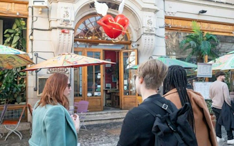 Visitors exploring a café in Bucharest Old Town during a city highlights walking tour.