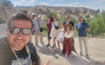 Group of tourists on Cappadocia Red Tour with rock formations in the background.
