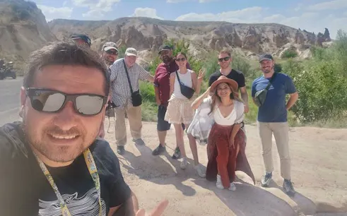 Group of tourists on Cappadocia Red Tour with rock formations in the background.