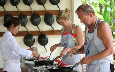 Cooking class participants preparing dishes at Baan Hongnual, Chiang Mai.