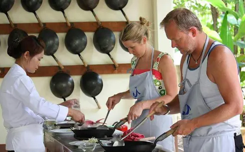 Cooking class participants preparing dishes at Baan Hongnual, Chiang Mai.
